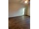 Bedroom with light-filled window, ceiling fan, and neutral walls over wood-look flooring at 627 Vagabond St, The Villages, FL 32163