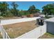 Aerial view of the backyard with a full privacy fence, pergola, and mature trees at 6671 Se 108Th St, Belleview, FL 34420