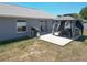 Backyard featuring covered patio area with seating, grill, and well-kept lawn at 6671 Se 108Th St, Belleview, FL 34420