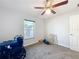Bright bedroom featuring neutral walls, carpeted floors, ceiling fan and a window providing natural light at 6671 Se 108Th St, Belleview, FL 34420