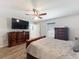 Spacious main bedroom with light wood flooring, ceiling fan, and wooden furniture at 6671 Se 108Th St, Belleview, FL 34420