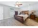 Main bedroom featuring wood flooring, wood furniture, ceiling fan, and lots of light at 6671 Se 108Th St, Belleview, FL 34420
