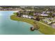 Scenic aerial view featuring a lake, a pier, lush green landscapes, and community buildings at 7503 Sw 97Th Terrace Rd, Ocala, FL 34481
