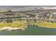 An aerial view of single-Gathering homes bordering a community golf course with sand traps and a large pond at 7503 Sw 97Th Terrace Rd, Ocala, FL 34481
