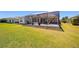 Wide backyard showcasing a screened-in patio with outdoor furniture and a lush green lawn at 7503 Sw 97Th Terrace Rd, Ocala, FL 34481