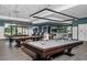 A bright billiards room featuring well-maintained pool tables, modern lighting, and comfortable seating at 7503 Sw 97Th Terrace Rd, Ocala, FL 34481