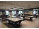 Well-lit billiards room with modern lighting, multiple pool tables, and comfortable seating at 7503 Sw 97Th Terrace Rd, Ocala, FL 34481