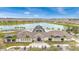 An aerial view showcasing the clubhouse set against a picturesque lake and residential backdrop at 7503 Sw 97Th Terrace Rd, Ocala, FL 34481