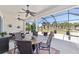 Relaxing screened patio features dining area, ceiling fans, a hot tub, and scenic golf course views at 7503 Sw 97Th Terrace Rd, Ocala, FL 34481