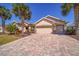 Beautiful single Gathering home featuring a well-manicured lawn, mature palm trees, brick driveway, and 3-car garage at 7503 Sw 97Th Terrace Rd, Ocala, FL 34481