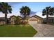 Beautiful single Gathering home featuring a well-manicured lawn, mature palm trees, brick driveway, and 3-car garage at 7503 Sw 97Th Terrace Rd, Ocala, FL 34481