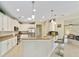 Well-lit kitchen featuring white cabinets, stainless steel appliances, and bar seating in an open concept design at 7503 Sw 97Th Terrace Rd, Ocala, FL 34481