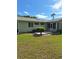 Backyard featuring a patio, a small sunroom, green grass and landscaping at 8107 Sw 108Th Place Rd, Ocala, FL 34481