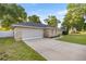 Side view of a beautiful single-story home with a spacious two-car garage and driveway at 8215 Sw 53Rd Ct, Ocala, FL 34476