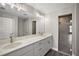 Modern bathroom with double sink vanity featuring quartz countertops, white cabinets, and a frameless glass-enclosed shower at 8725 Sw 136Th Ter, Dunnellon, FL 34432