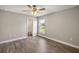 Bedroom with light-colored walls, wood-look floors, and a view into the attached bathroom and exterior through the window at 8725 Sw 136Th Ter, Dunnellon, FL 34432