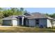 Beautiful single-story home with a gray exterior, complemented by lush landscaping and a well-manicured lawn at 8725 Sw 136Th Ter, Dunnellon, FL 34432