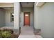 Inviting front porch with stone accents on the columns and a vibrant red front door at 8725 Sw 136Th Ter, Dunnellon, FL 34432