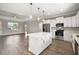 Modern kitchen with stainless steel appliances, white cabinetry, quartz countertops, and center island open to the living area at 8725 Sw 136Th Ter, Dunnellon, FL 34432