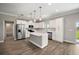 Modern white kitchen with stainless steel appliances, a center island, and hardwood floors at 8725 Sw 136Th Ter, Dunnellon, FL 34432
