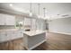 Bright kitchen boasts white cabinets, quartz countertops, stainless steel appliances, and center island with pendant lighting at 8725 Sw 136Th Ter, Dunnellon, FL 34432