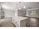Open concept kitchen features a center island with white cabinets and quartz countertops, connecting seamlessly to the living area at 8725 Sw 136Th Ter, Dunnellon, FL 34432
