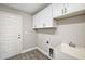 A well-organized laundry room with sleek white cabinets, modern sink, and stylish flooring at 8725 Sw 136Th Ter, Dunnellon, FL 34432