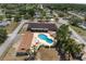 An aerial view highlights an outdoor community pool, landscaping, and nearby buildings at 10040 Sw 93Rd Ct, Ocala, FL 34481