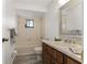 Cozy bathroom with a tub/shower combo, single sink vanity, and a decorative mirror at 10040 Sw 93Rd Ct, Ocala, FL 34481