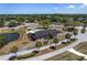 Aerial view of a clubhouse featuring a pool, palm trees, and ample parking in a picturesque community at 10040 Sw 93Rd Ct, Ocala, FL 34481