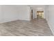 Spacious living room featuring gray wood-look flooring and neutral walls with a dining room in the background at 10040 Sw 93Rd Ct, Ocala, FL 34481