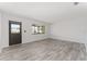 Spacious living room featuring gray wood-look flooring and neutral walls with large windows at 10040 Sw 93Rd Ct, Ocala, FL 34481