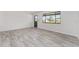 Spacious living room featuring gray wood-look flooring and neutral walls with large windows at 10040 Sw 93Rd Ct, Ocala, FL 34481