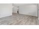Spacious living room featuring gray wood-look flooring and neutral walls with a glimpse into the bathroom at 10040 Sw 93Rd Ct, Ocala, FL 34481