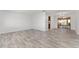 Spacious living room featuring gray wood-look flooring and neutral walls with a dining room in the background at 10040 Sw 93Rd Ct, Ocala, FL 34481