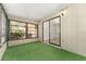 This sunroom has green carpet with a door to the outside and slider into the home at 10040 Sw 93Rd Ct, Ocala, FL 34481