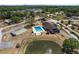Aerial view of community pool with a spa and lounge area, nestled beside a serene pond and clubhouse at 10040 Sw 93Rd Ct, Ocala, FL 34481