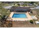Aerial view of a refreshing pool with lounge area and hot tub, set in a meticulously maintained community space at 10040 Sw 93Rd Ct, Ocala, FL 34481