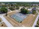 Aerial view of well-maintained tennis courts surrounded by lush greenery in a vibrant community setting at 10040 Sw 93Rd Ct, Ocala, FL 34481