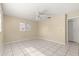 Bright, neutral bedroom featuring tile flooring and ceiling fan for a comfortable living space at 10946 Sw 65Th Ave, Ocala, FL 34476