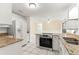 Updated kitchen showcasing granite countertops, stainless appliances, tile floors, and white cabinetry at 10946 Sw 65Th Ave, Ocala, FL 34476