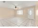 Bright living room featuring neutral paint, tile floors, a ceiling fan, and an inviting entry door at 10946 Sw 65Th Ave, Ocala, FL 34476