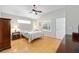Cozy bedroom with hardwood floors, ceiling fan, and a window letting in natural light at 11133 Sw 73Rd Ter, Ocala, FL 34476