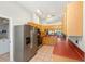 Well-lit kitchen with modern stainless steel refrigerator, wood cabinets, and vaulted ceiling at 11133 Sw 73Rd Ter, Ocala, FL 34476