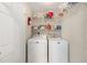 Functional laundry room with white appliances and shelving for supplies at 11133 Sw 73Rd Ter, Ocala, FL 34476