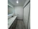 Modern bathroom with a large, illuminated mirror and gray vanity at 11921 Se 169Th Avenue Rd, Ocklawaha, FL 32179