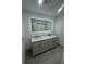 Modern bathroom featuring a double sink vanity with a lighted mirror at 11921 Se 169Th Avenue Rd, Ocklawaha, FL 32179