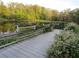 Wooden boardwalk with benches overlooking a lake, surrounded by lush greenery and trees at 11921 Se 169Th Avenue Rd, Ocklawaha, FL 32179