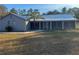 Charming single-story home with a screened-in porch and a lush green lawn at 11921 Se 169Th Avenue Rd, Ocklawaha, FL 32179