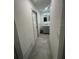 Hallway leading to a modern bathroom featuring a gray vanity and light gray floors at 11921 Se 169Th Avenue Rd, Ocklawaha, FL 32179